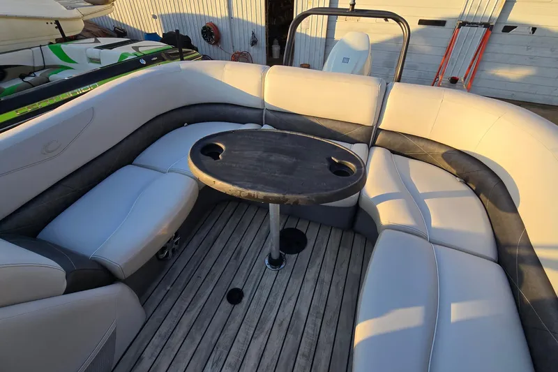 Slide: The Image of 2017 Crest Classic 230 SLC boat interior with curved seating and round table. - 19