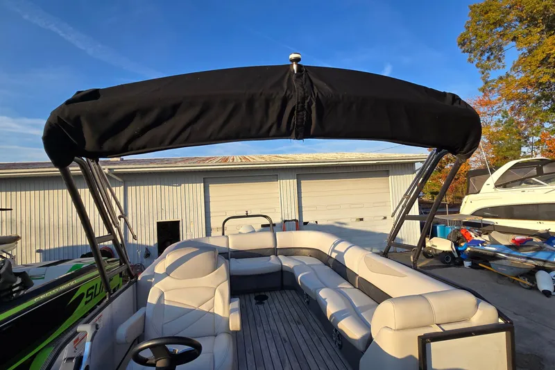 Slide: The Image of 2017 Crest Classic 230 SLC pontoon boat with black canopy and spacious seating. - 20