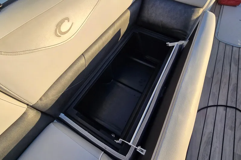 Slide: The Image of 2017 Crest Classic 230 SLC boat seat storage compartment open on deck. - 38