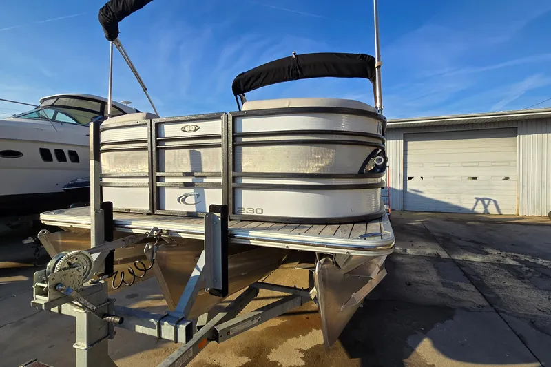 Slide: The Image of 2017 Crest Classic 230 SLC pontoon boat on trailer, sunny day, marina background. - 4