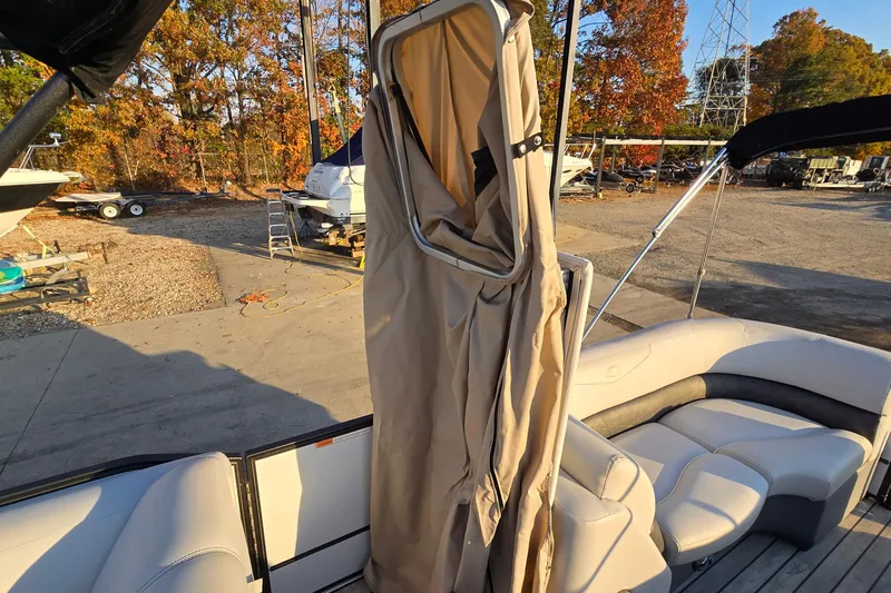 Slide: The Image of 2017 Crest Classic 230 SLC pontoon boat with beige interior and privacy curtain, docked outdoors. - 43