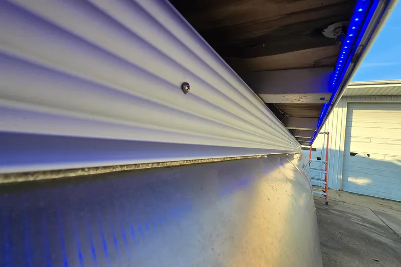 Slide: The Image of 2017 Crest Classic 230 SLC pontoon boat with blue LED lights, side view. - 46