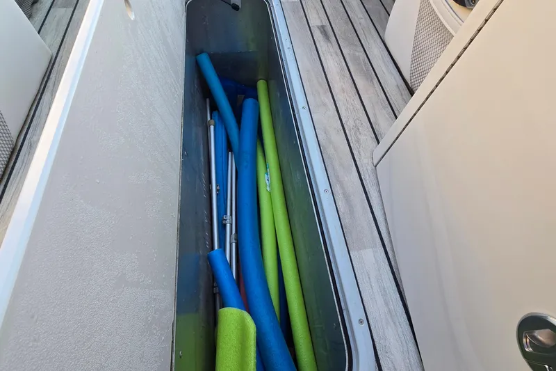 Slide: The Image of Storage compartment on 2017 Crest Classic 230 SLC boat with pool noodles and equipment. - 51