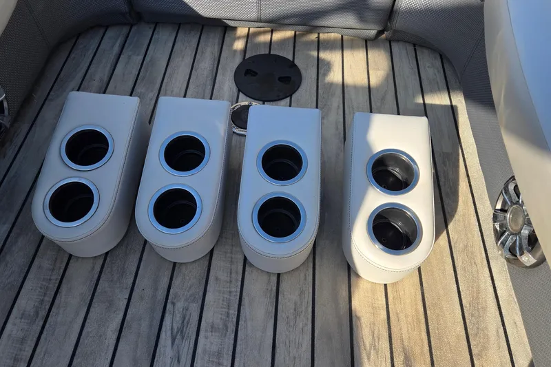 Slide: The Image of Four cup holders on a 2017 Crest Classic 230 SLC boat's wooden deck. - 53