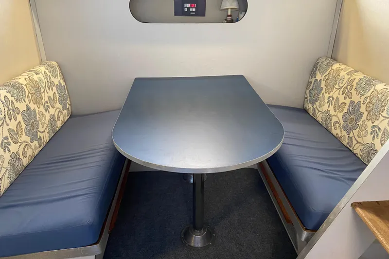 Slide: The Image of 1987 Carver 32 Montego interior with blue cushioned seating and floral-patterned backrests. - 10