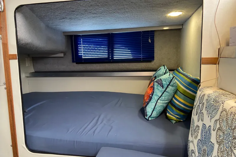 Slide: The Image of Cozy cabin interior of 1987 Carver 32 Montego with colorful pillows and blue blinds. - 16