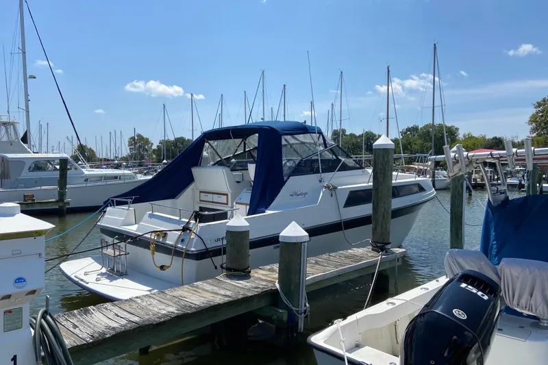 Slide: The Image of 1987 Carver 32 Montego yacht docked at marina under clear blue sky. - 2