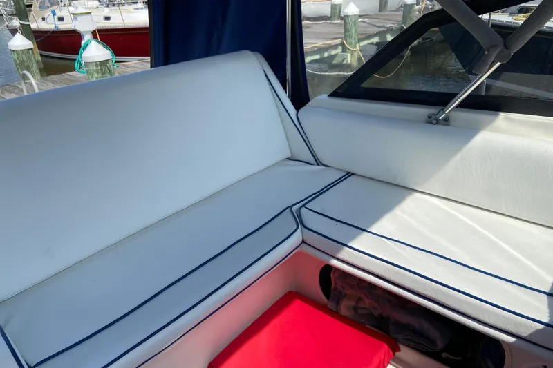 Slide: The Image of Interior seating of 1987 Carver 32 Montego boat with white cushions and red storage. - 6