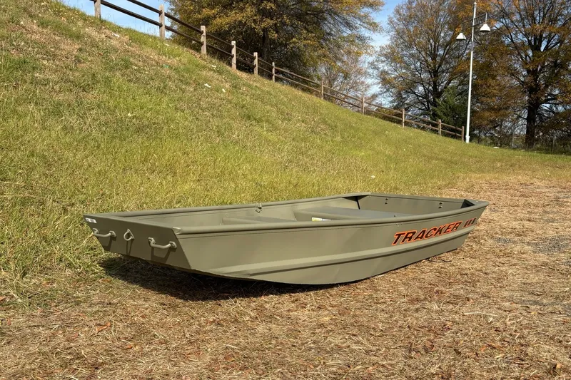 Slide: The Image of 2026 Tracker Grizzly 10 Jon boat on grassy terrain, under clear sky. - 5
