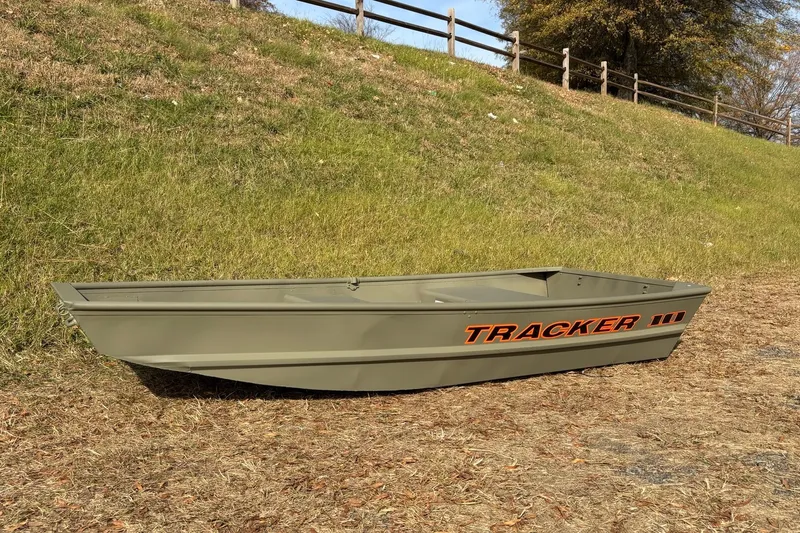 Slide: The Image of 2026 Tracker Grizzly 10 Jon boat on grassy terrain, showcasing durable design and branding. - 4