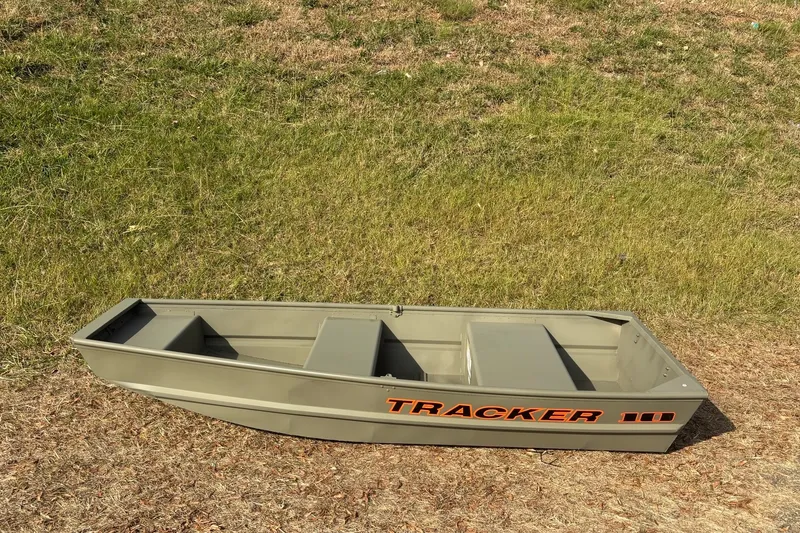 Slide: The Image of 2026 Tracker Grizzly 10 Jon boat on grassy terrain, showcasing its compact design. - 6