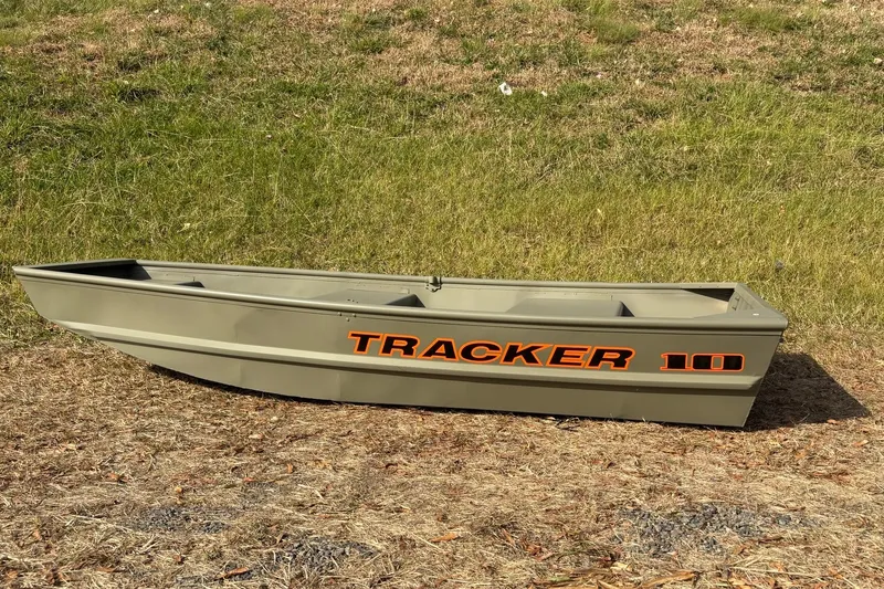 Slide: The Image of 2026 Tracker Grizzly 10 Jon boat on grassy terrain, showcasing its sturdy design. - 10