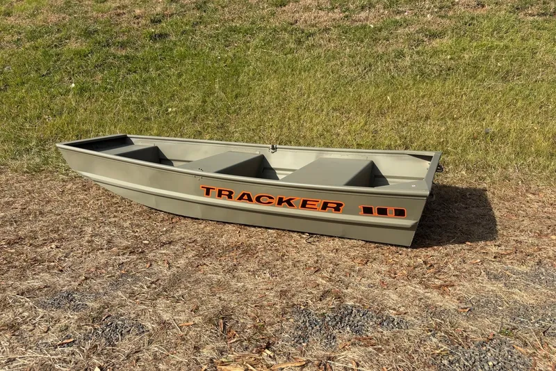 Slide: The Image of 2026 Tracker Grizzly 10 Jon boat on grassy terrain, showcasing its sturdy design. - 3