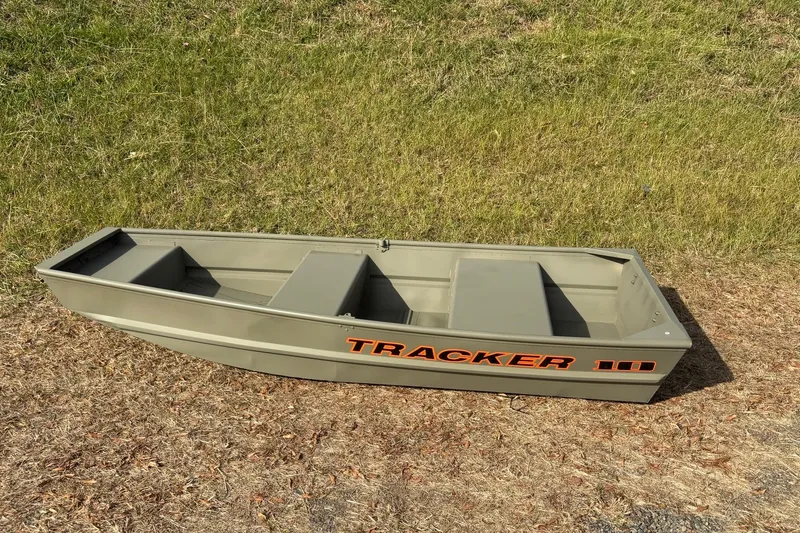 Slide: The Image of 2026 Tracker Grizzly 10 Jon boat on grassy terrain, showcasing its compact design. - 7