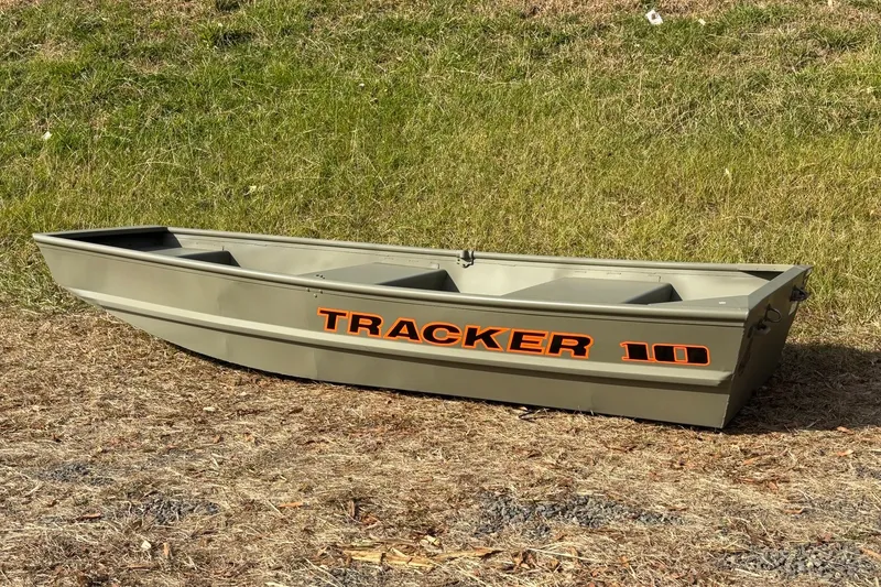 Slide: The Image of 2026 Tracker Grizzly 10 Jon boat on grassy terrain, showcasing durable design and compact size. - 12