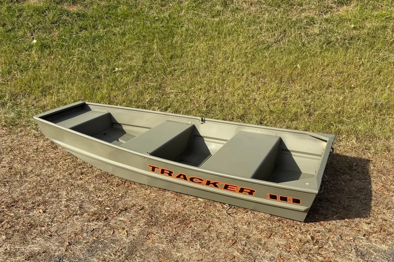 Slide: The Image of 2026 Tracker Grizzly 10 Jon boat on grassy terrain, showcasing durable design. - 9
