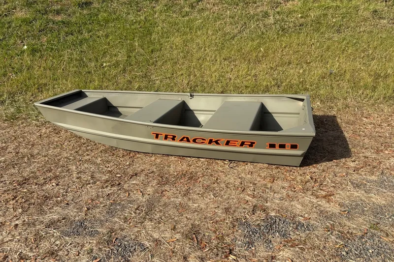The Image of 2026 Tracker Grizzly 10 Jon boat on grassy terrain, showcasing durable design. - 0
