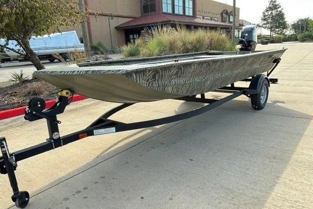 The Image of 2026 Tracker Grizzly 1754 Utility boat on trailer, parked outdoors. - 0