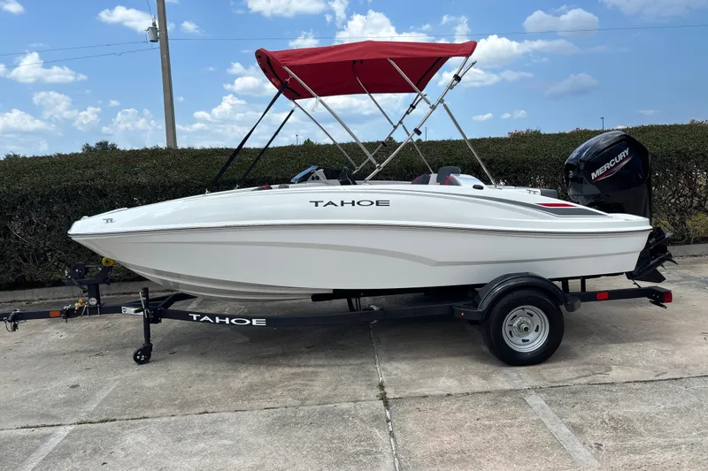 The Image of 2026 Tahoe T16 boat with red canopy on trailer, parked outdoors. - 0