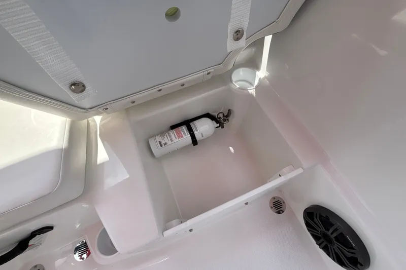 Slide: The Image of Storage compartment in a 2026 Tahoe T16 boat with a secured fire extinguisher. - 22