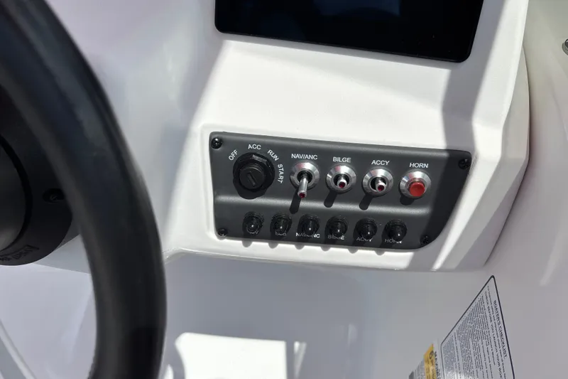 Slide: The Image of Dashboard controls of a 2026 Tahoe T16 boat, featuring switches and ignition. - 16