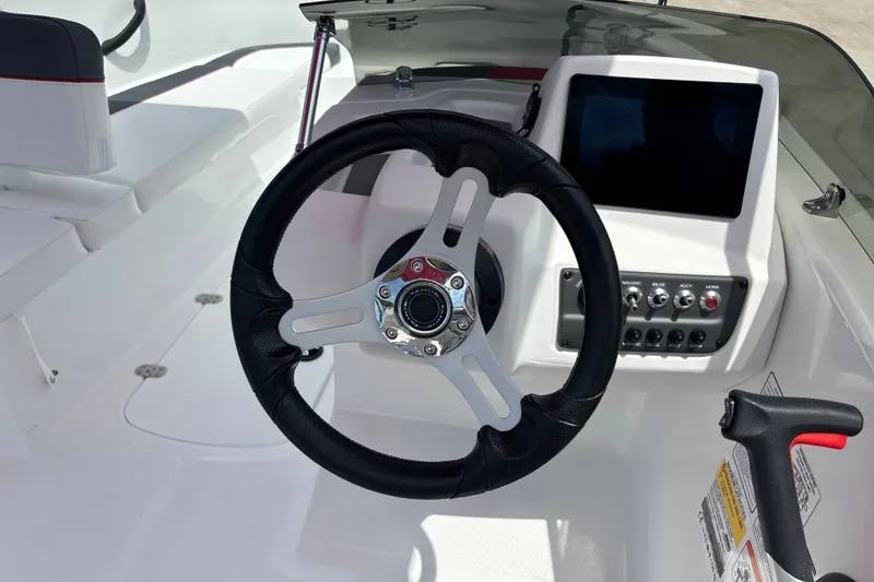 Slide: The Image of Steering wheel and dashboard of 2026 Tahoe T16 boat, featuring modern controls and display. - 13