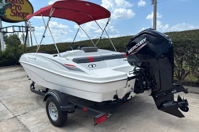 Slide: The Image of 2026 Tahoe T16 boat with Mercury outboard motor, parked on a trailer under a red canopy. - 2