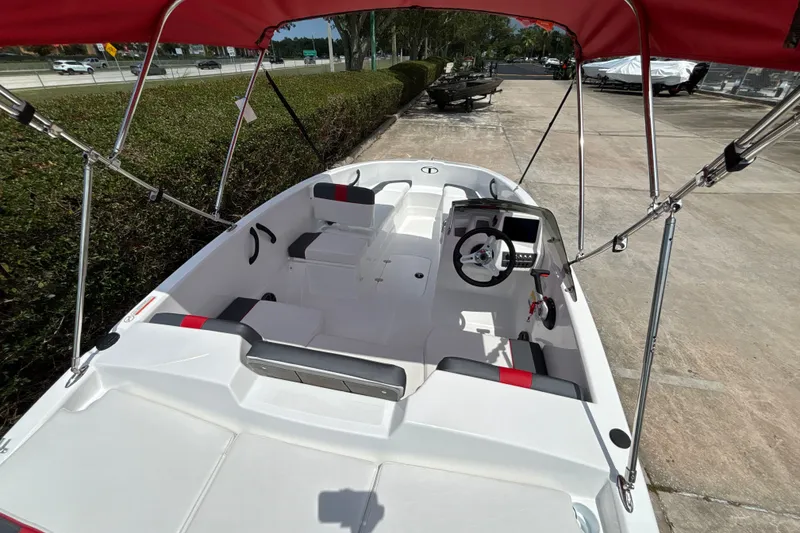 Slide: The Image of 2026 Tahoe T16 boat interior with red canopy, white seating, and steering console. - 10