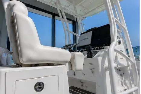Slide: The Image of 2026 Mako 24 APEX boat interior with white seating and modern controls. - 1