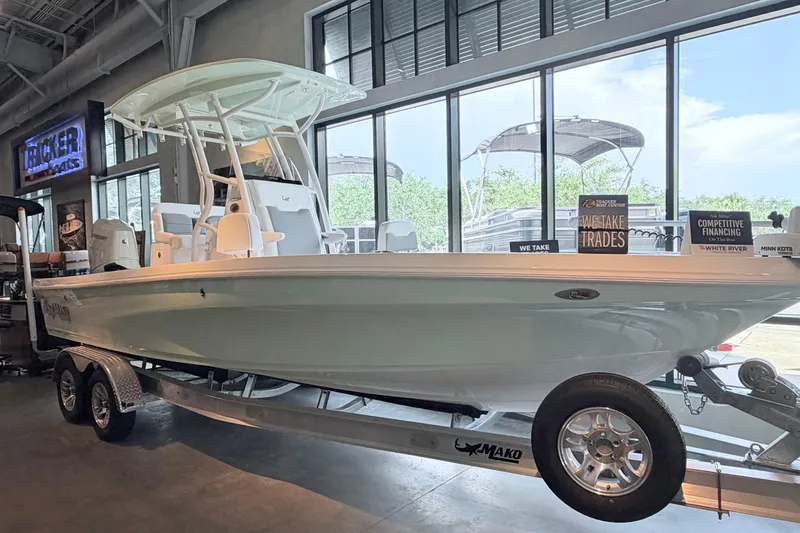 Slide: The Image of 2026 Mako 24 APEX boat displayed indoors on a trailer, showcasing sleek design and modern features. - 6