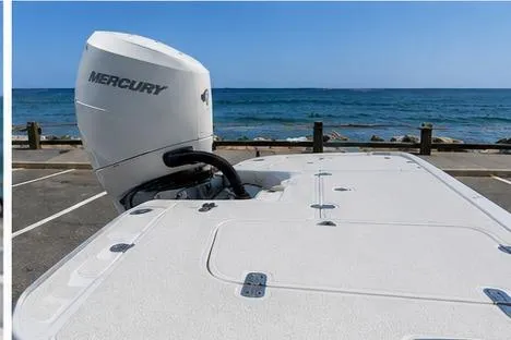 Slide: The Image of 2026 Mako 24 APEX boat with Mercury engine, parked by the ocean. - 4