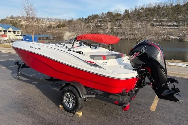 Slide: The Image of 2026 Tahoe T18 boat with red hull and outboard motor on trailer by a lake. - 75