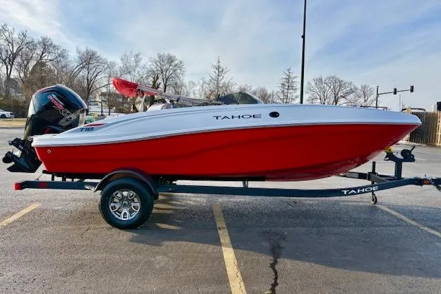 Slide: The Image of 2026 Tahoe T18 boat with red and white design on a trailer in a parking lot. - 76