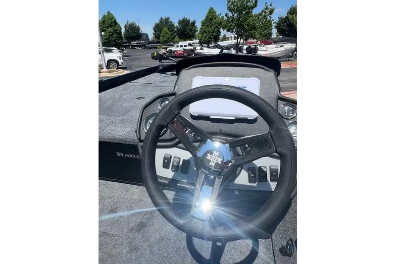 Slide: The Image of 2026 Ranger RT188P boat dashboard with steering wheel and control panel in sunlight. - 11