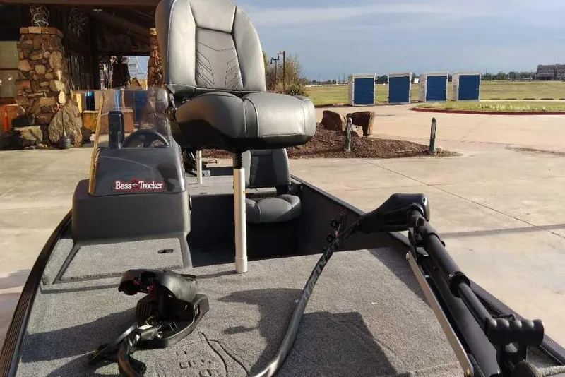 Slide: The Image of 2026 Tracker Bass Tracker Classic XL boat with seating and trolling motor, displayed outdoors. - 2