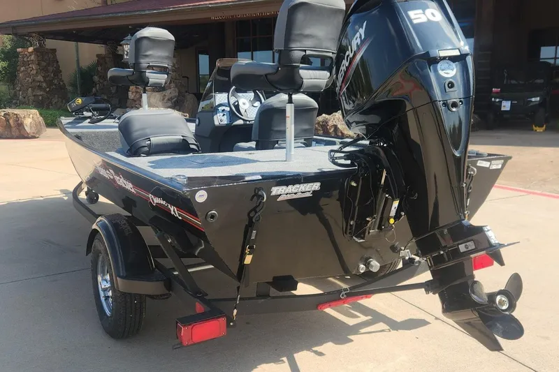 Slide: The Image of 2026 Tracker Bass Tracker Classic XL boat with Mercury 50 engine, parked outdoors. - 7