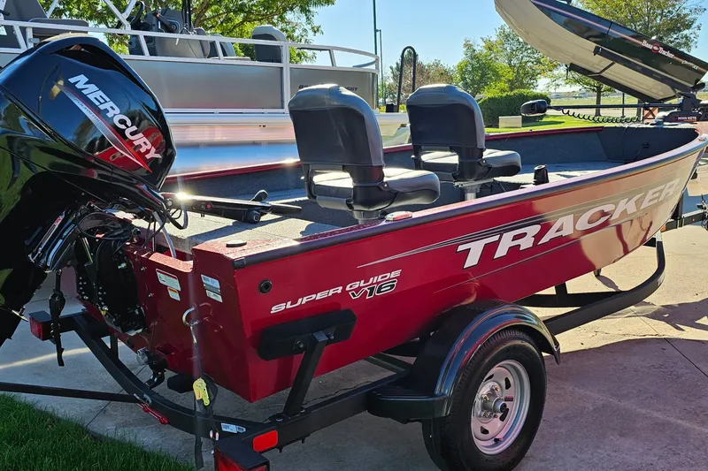Slide: The Image of 2026 Tracker Super Guide V-16 T boat with Mercury engine, parked outdoors. - 14