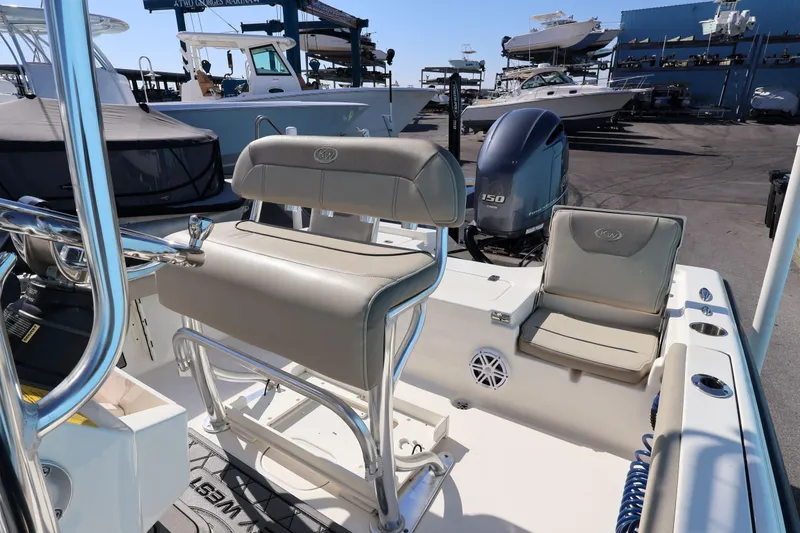 Slide: The Image of 2023 Key West 210 Bay Reef boat interior with seating and motor at marina. - 26