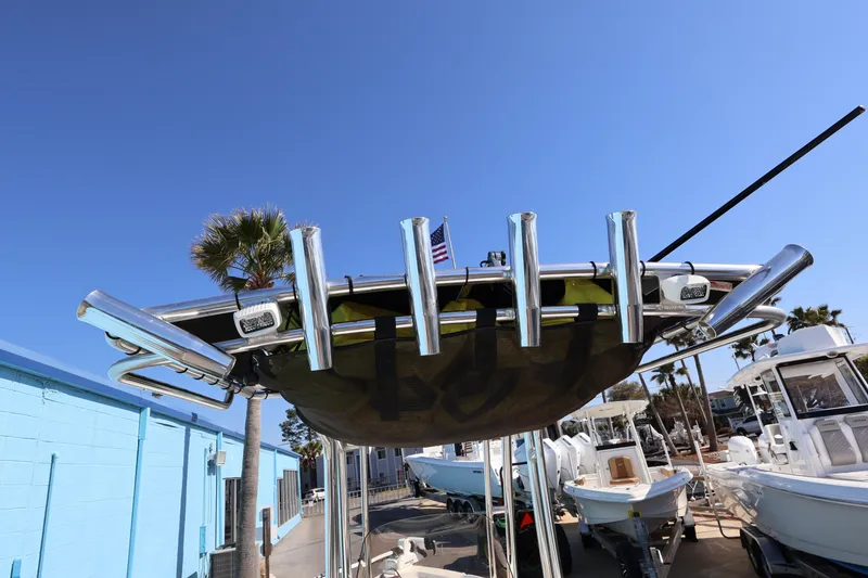 Slide: The Image of 2023 Key West 210 Bay Reef boat with rod holders, docked under clear blue sky. - 33
