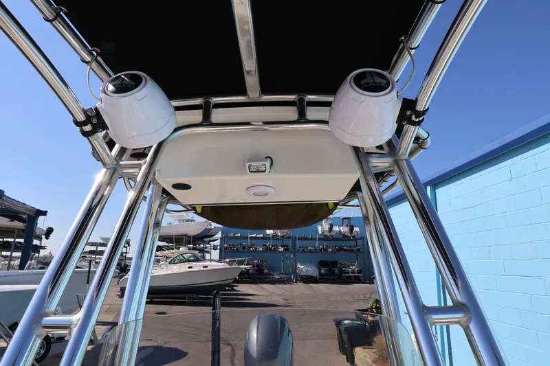 Slide: The Image of 2023 Key West 210 Bay Reef boat with T-top and speakers in a marina. - 34