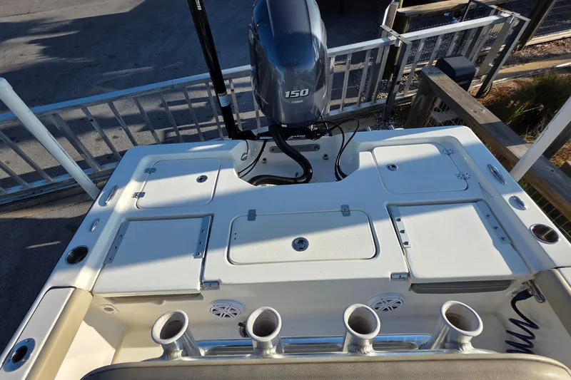Slide: The Image of 2023 Key West 210 Bay Reef boat with Yamaha 150 engine, featuring storage compartments and rod holders. - 8