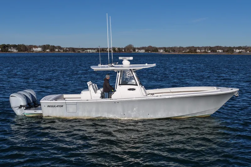 Slide: The Image of 2021 Regulator 34 boat cruising on a calm blue sea. - 1