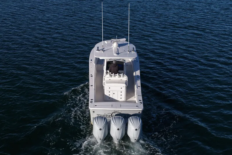 Slide: The Image of 2021 Regulator 34 boat cruising on open water with triple engines. - 13