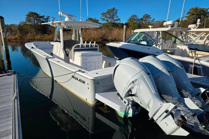 Slide: The Image of 2021 Regulator 34 boat docked with twin outboard engines, clear blue sky. - 19
