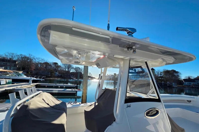Slide: The Image of 2021 Regulator 34 boat with T-top, docked in a serene marina setting. - 26