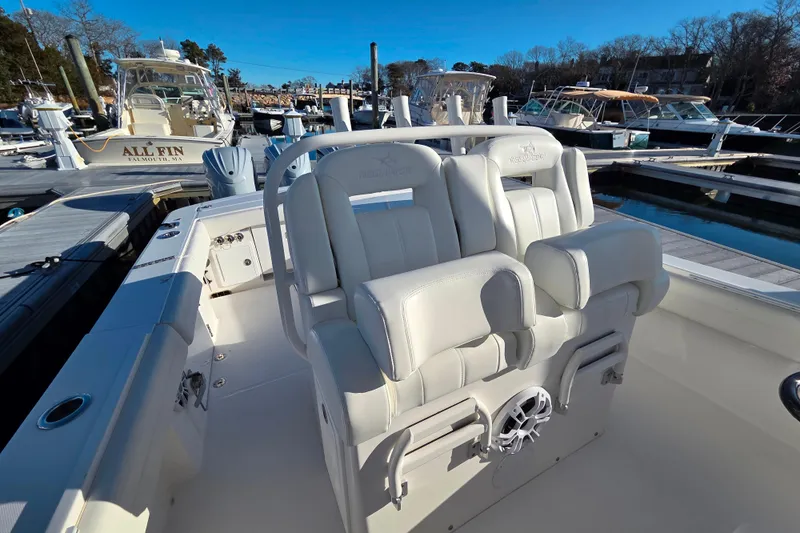 Slide: The Image of 2021 Regulator 34 boat with white seating at a marina dock. - 28
