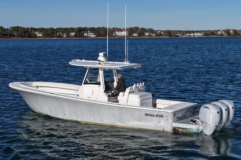 Slide: The Image of 2021 Regulator 34 boat on calm water with triple outboard engines. - 6