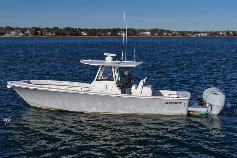 Slide: The Image of 2021 Regulator 34 boat on calm water, side view with outboard engines. - 7