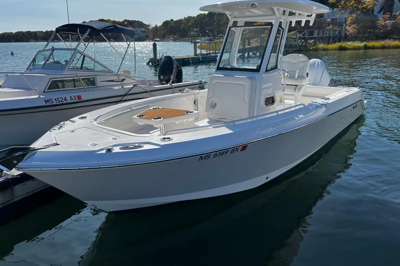 The Image of 2023 Edgewater 230CC boat docked on a sunny day, showcasing sleek design and modern features. - 1