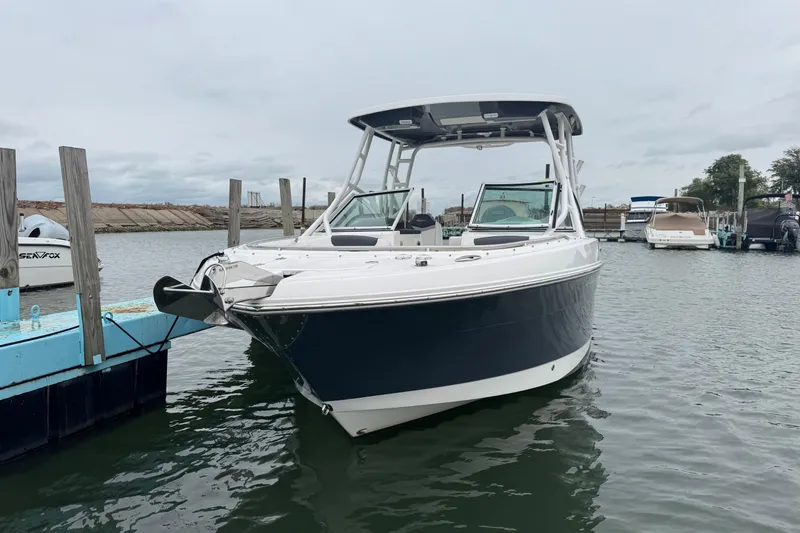The Image of 2022 Robalo R247 Dual Console boat docked in a marina. - 1